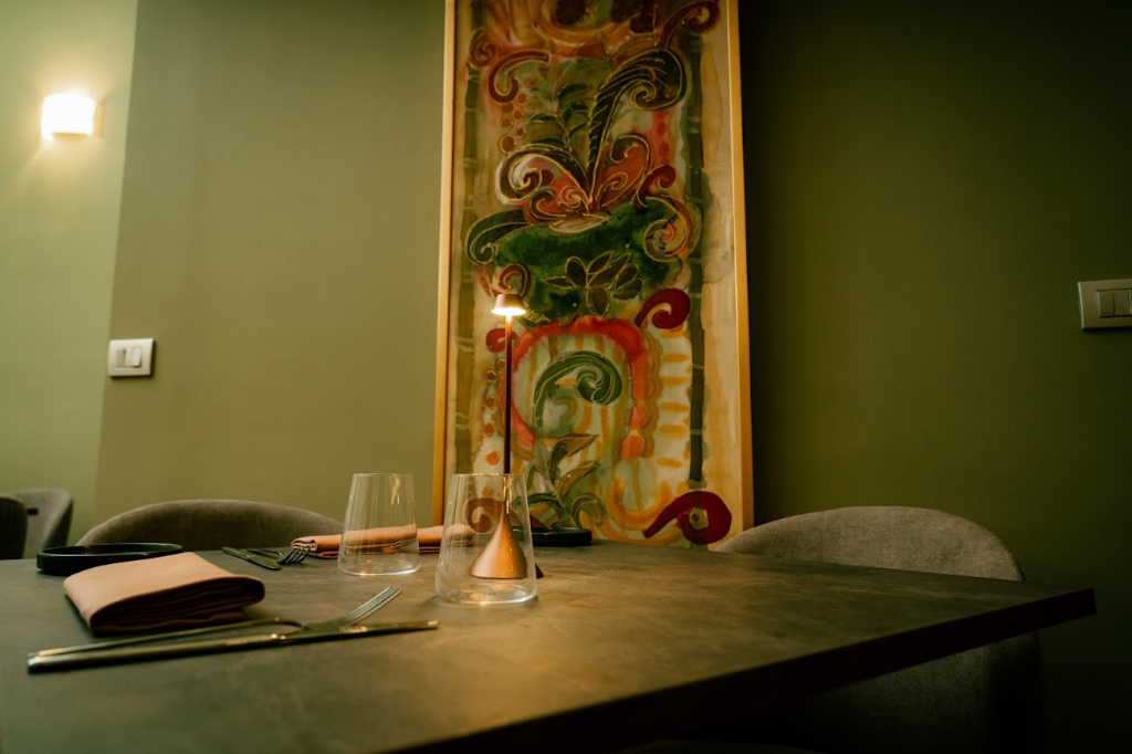 A convivial table set with fine crystal glasses, a designer lamp and a large canvas in the background