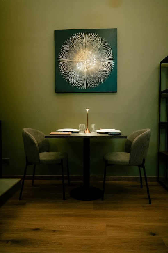 The intimacy of a table for two beneath the iconic radial light installation and a designer table lamp